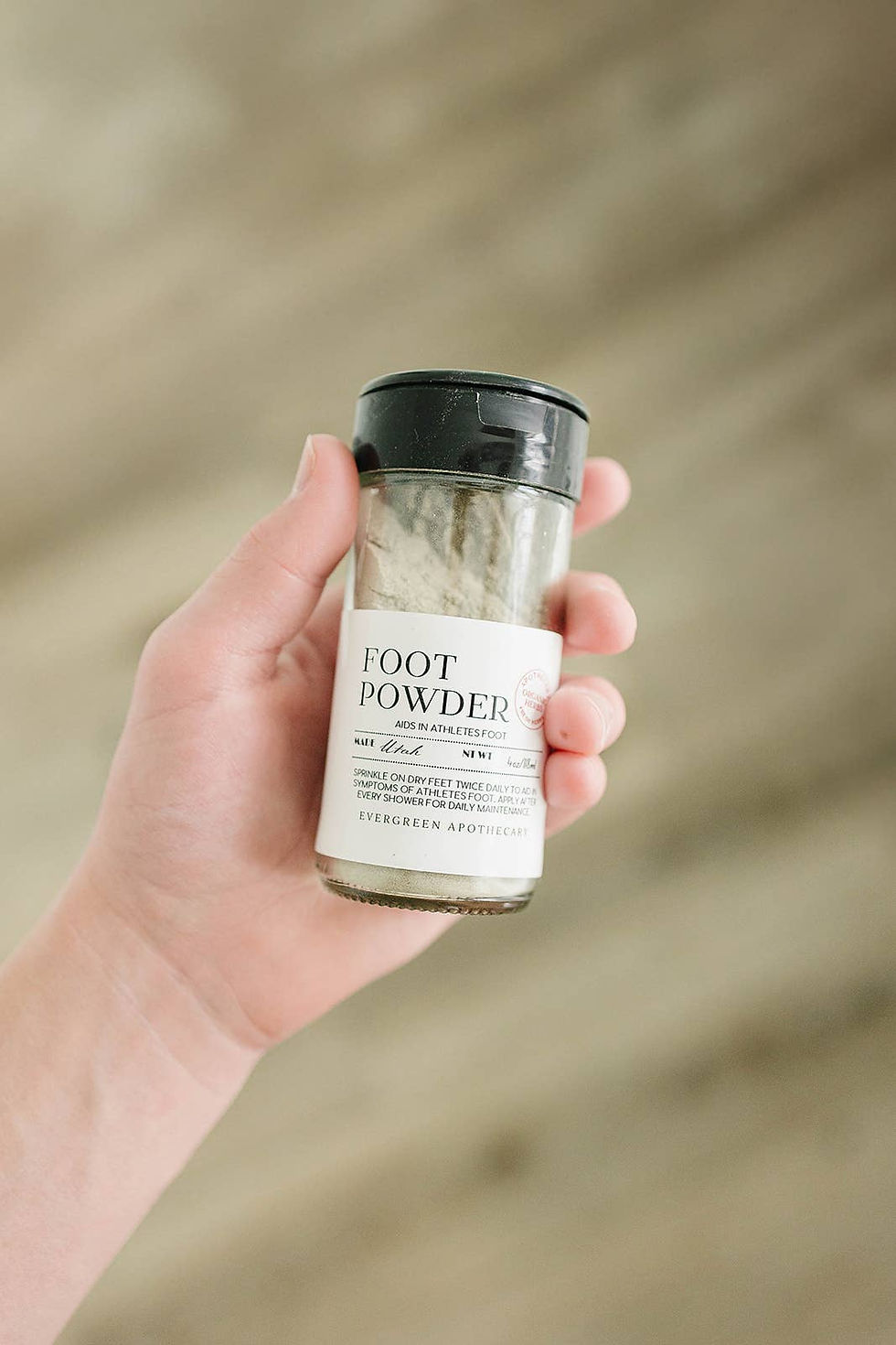 Hand holding Foot Powder jar