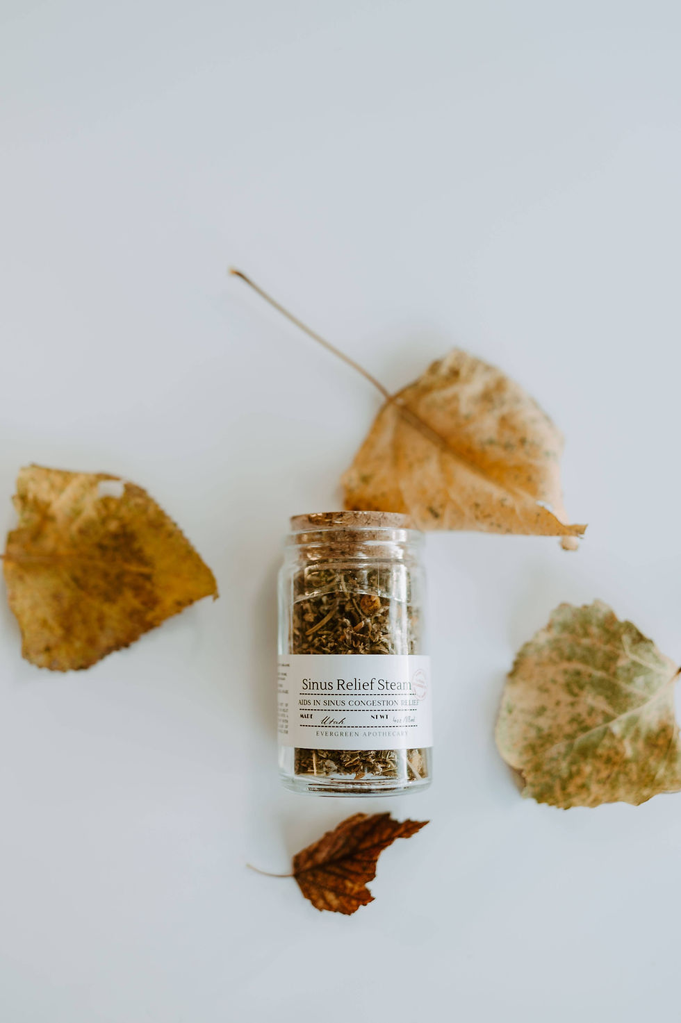 Small jar of dried herbs and autumn leaves