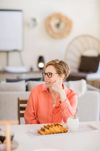 Rachel looking to her right with a pink shirt on and food in front of her