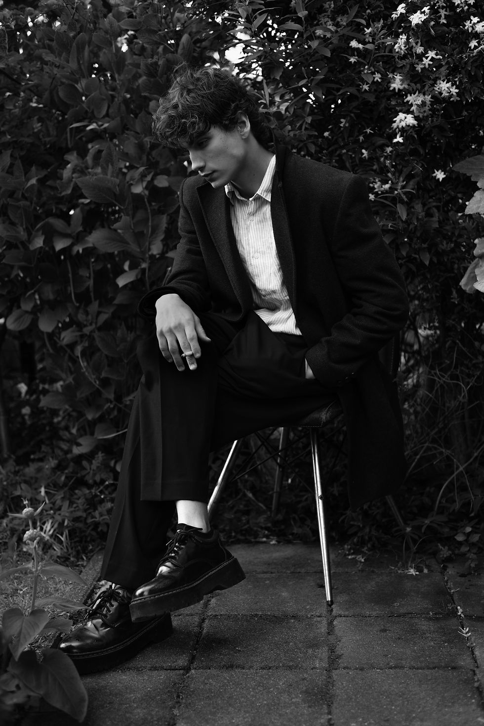Close-up black and white shot of Bruno Benetti looking directly at the lens, highlighting raw expression and natural light