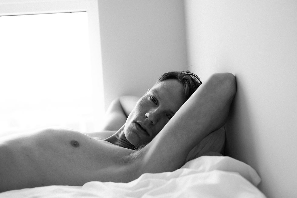 Soft sheets, hard light, and the quiet weight of being seen.