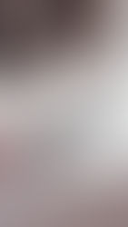 A smartphone on a bed with pink blanket, illuminated by morning light. A water bottle is blurred in the background, creating a cozy mood.