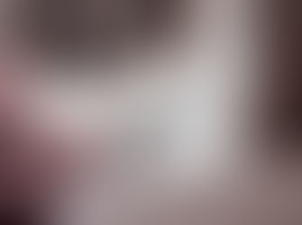 A smartphone on a bed with pink blanket, illuminated by morning light. A water bottle is blurred in the background, creating a cozy mood.