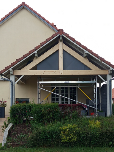 Charpente et toit recouvrant une terrasse de maison