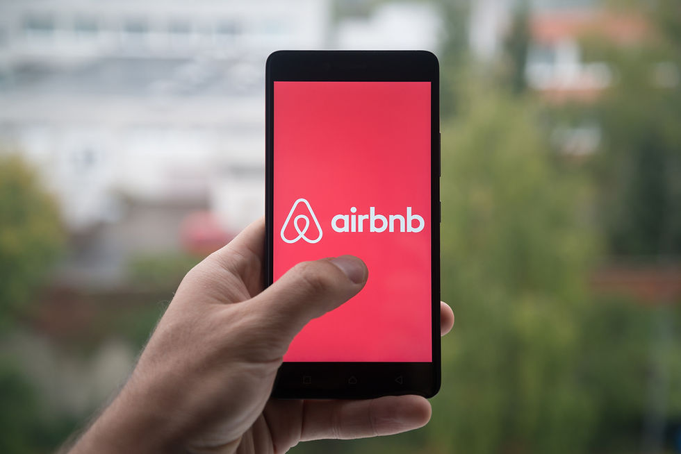 hand holding cell phone with Airbnb app on screen