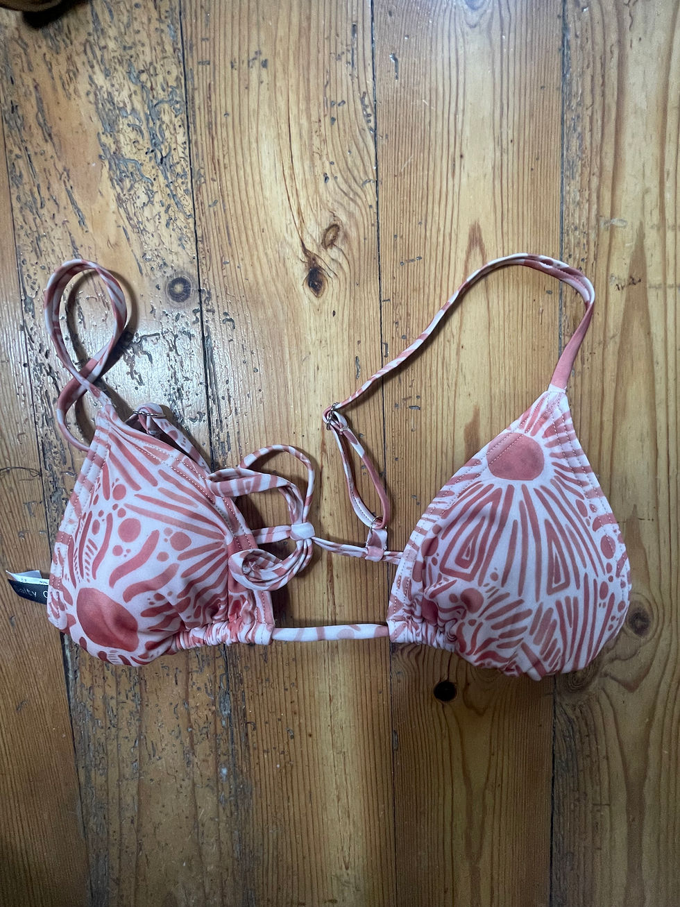 Thumbnail: front view of Lined, non-wired adjustable slider strap triangle bikini top in a burnt orange sun print