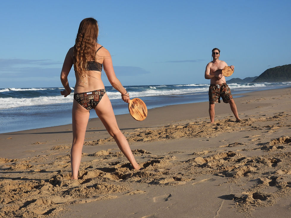 Thumbnail: girl and boy in matching swimwear playing beach bat and ball in Mozambique