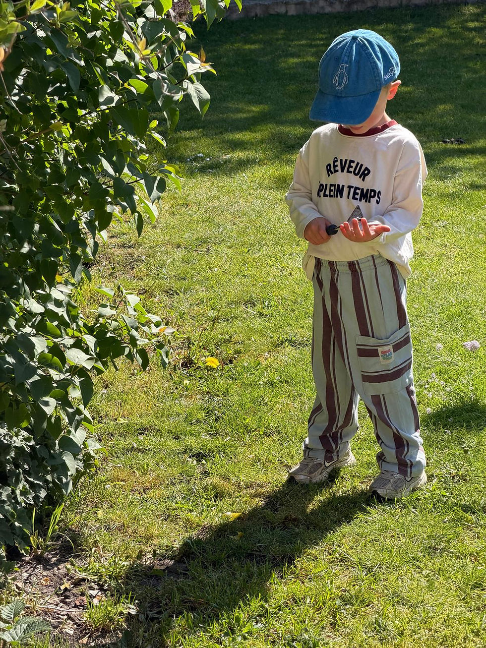 Thumbnail: Turquoise Kids Cap embroidered with a penguin, on a little boy in the garden