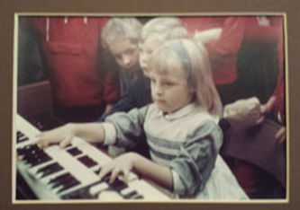 Childhood photo of Shirley Cason playing keyboards, guided by family encouragement.