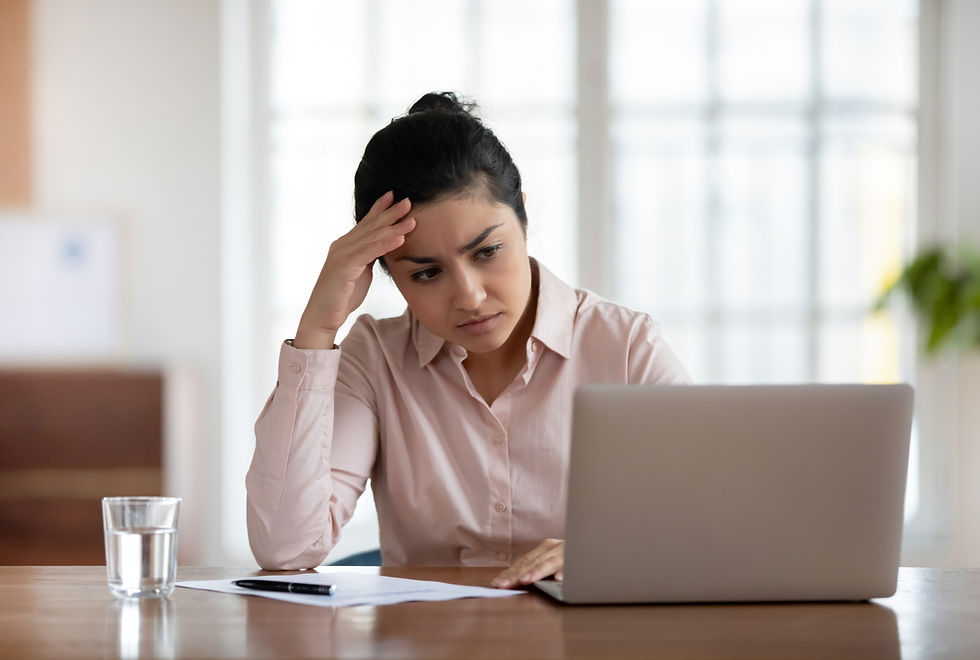 An anxious and stressed-out female Indian employee at work.