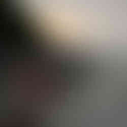 Woman ina coral rian jacket scooping water out of a lake