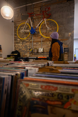 A woman in a record store, with records in the forefront