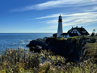 The Portland Head Light lighthouse standing along Maine’s rocky coastline with the Atlantic Ocean in the background — featured by Cruising Reitz for the “Big Fun, Small Budget” travel blog, showcasing affordable family adventures.