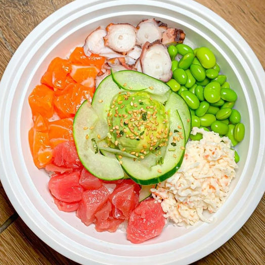 Large poke bowl with a base of sushi rice. 4 proteins of 2 scoops of ahi tuna, 1 scoop of salmon, 1 scoop of octopus. Cucumbers, avocado, edamame, and crab meat as toppings. Sprinkled with seaweed and sesame seeds.
