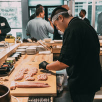 Sushi chef crafting nigiri behind the counter at a premium sushi restaurant in Santa Ana, Orange County, CA, captured for Instagram marketing.