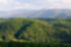 Cove with rolling hills in front of larger mountains