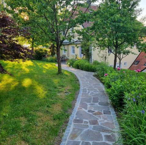 Gartenweg mit mosaikartig verlegten Natursteinen