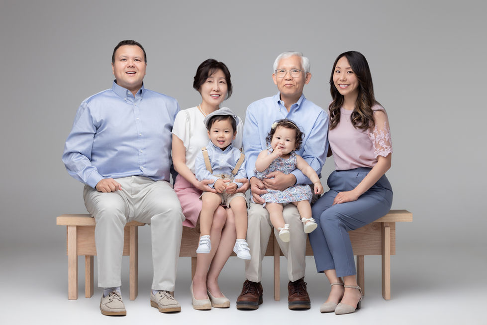 Multigenerational family posing together for a studio portrait.