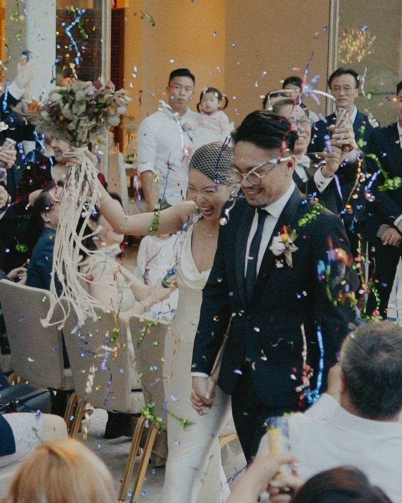 Couple walking down the aisle through confetti