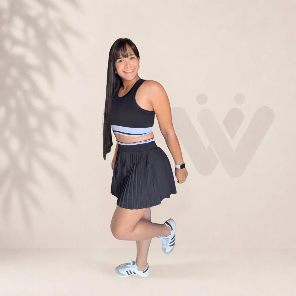 Mujer sonriente con top y falda deportiva negra