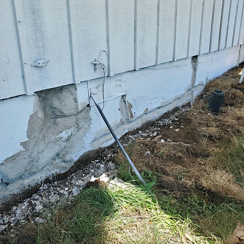 Cracked and spalling foundation with visible deterioration, showing significant structural damage that needs urgent repair