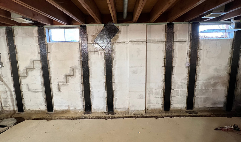 Bowed Wall Strengthening and Stabilization in a basement. Carbon fiber straps spaced 2-4 feet along along the foundation wall to stop bowing