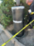 Carbon fiber being applied to concrete light pole foundation for structural reinforcement