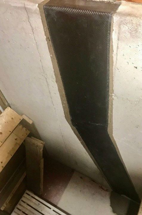 Image of a crack in a concrete structure after being filled and confined with carbon fiber reinforcement