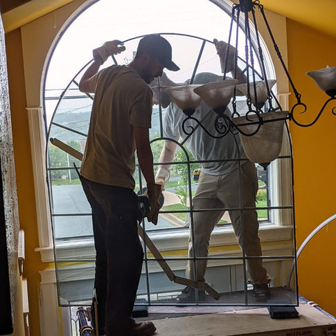 Workers installing glass in the house