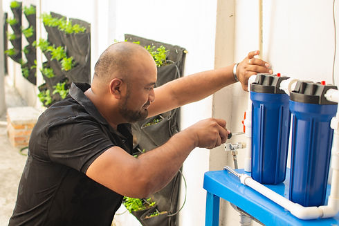 A man adjusts a water filter system on a wall