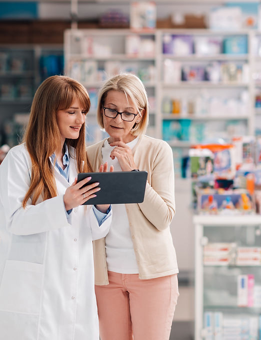 Pharmacist showing information on digital tablet to customer in drugstore