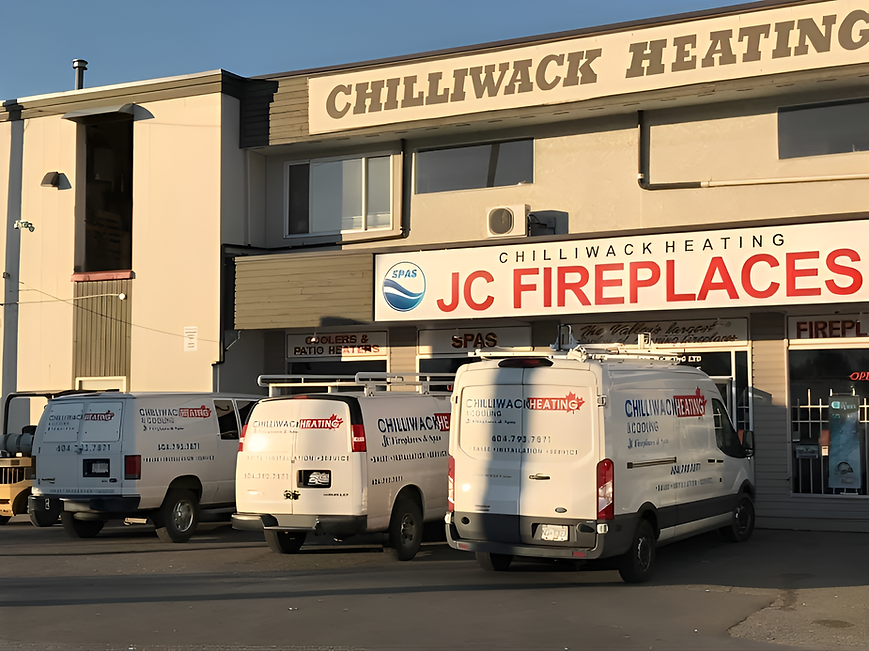 Four white service vans are parked outside a store with signage