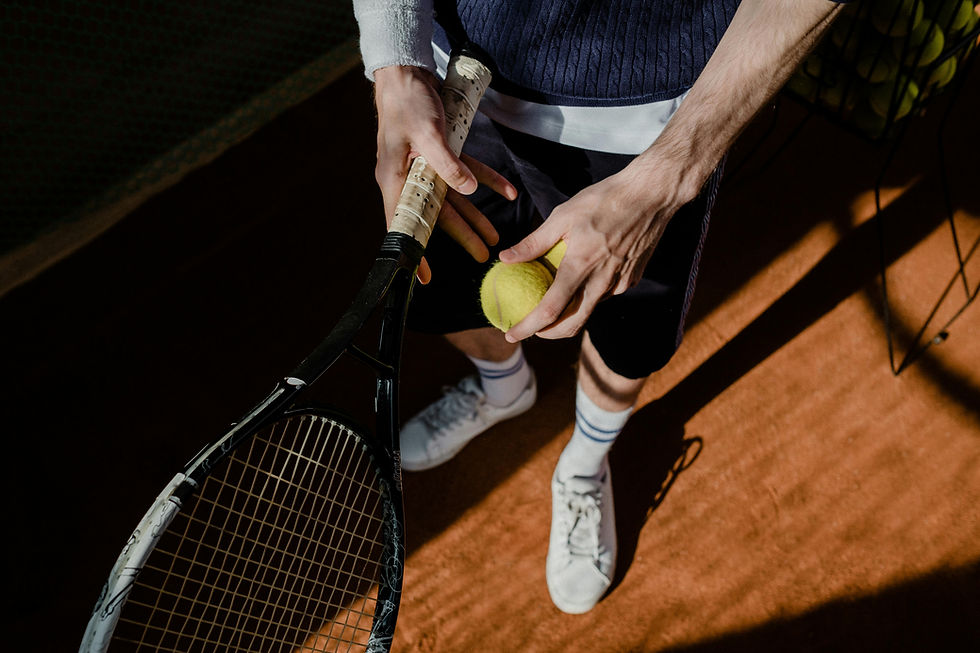 Close-up of a tennis player holding a tennis racket and a tennis ball