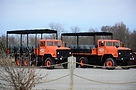 Two orange tour trucks parked