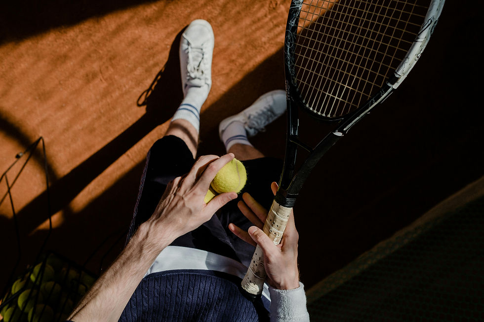 Tennis player holding two balls and racket
