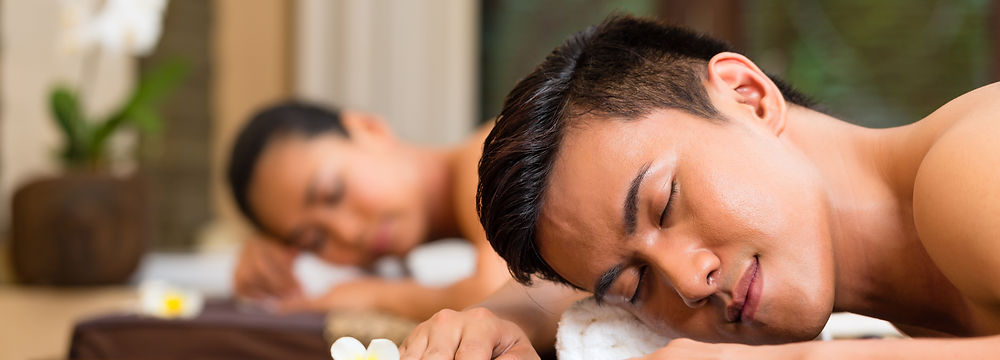 Man receiving a massage at Blossom Spa, relaxing with eyes closed
