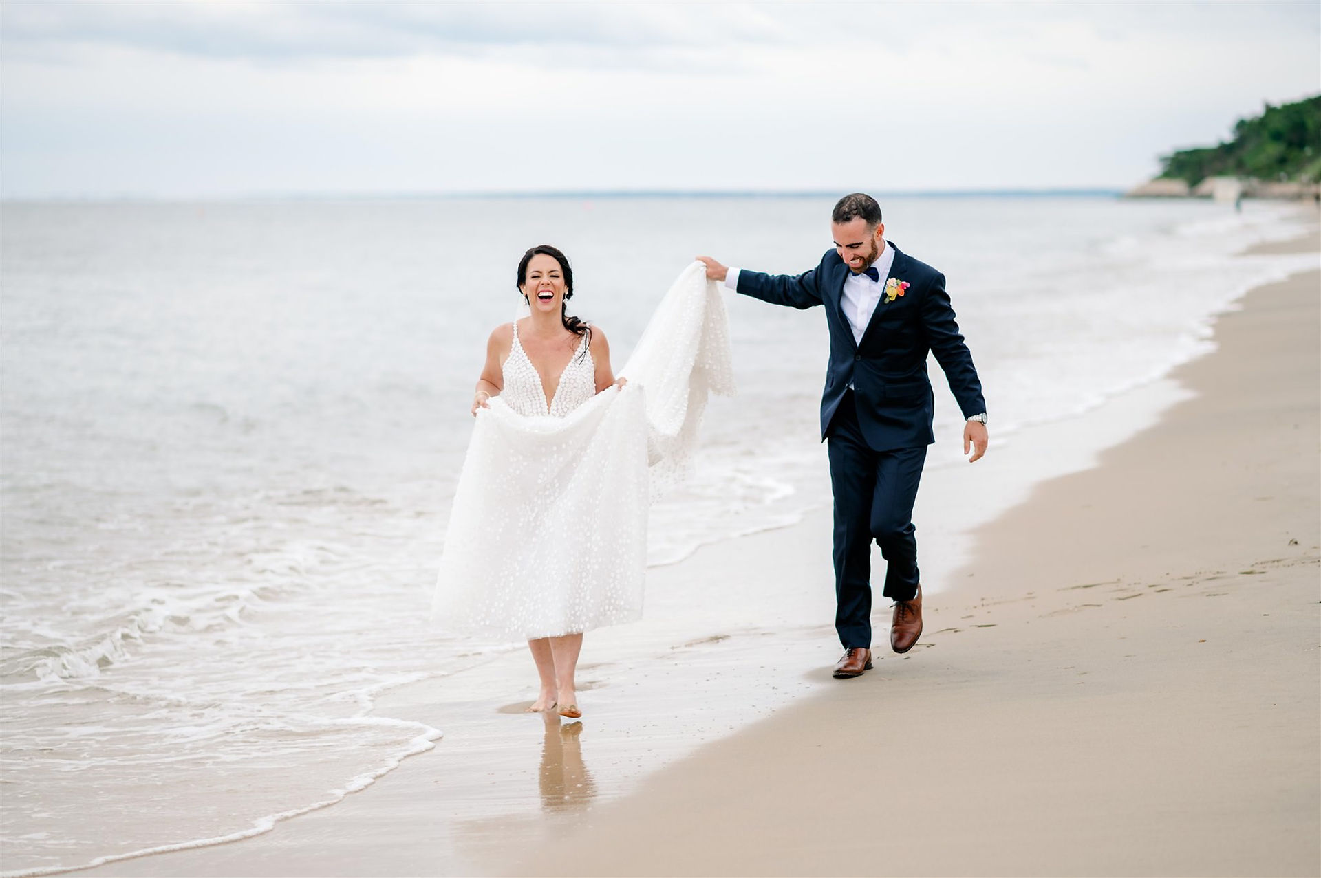 Bride and groom wedding portrait walking on the beach at Cape Cod