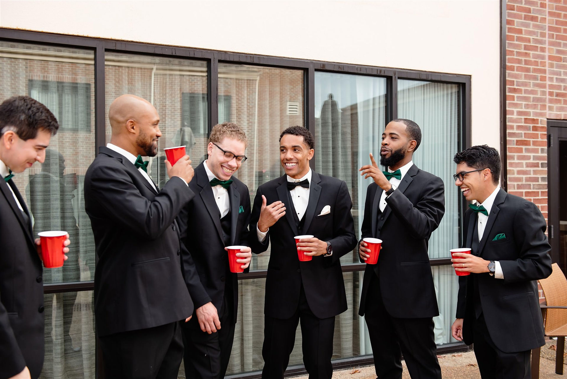 Groomsmen photo drinking from red cups and laughing