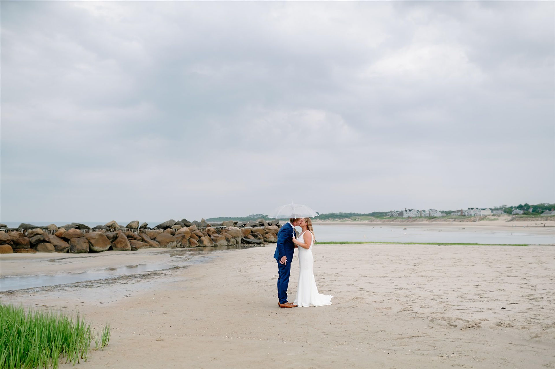 Wedding photo with bride and groom under umbrella in cape cod