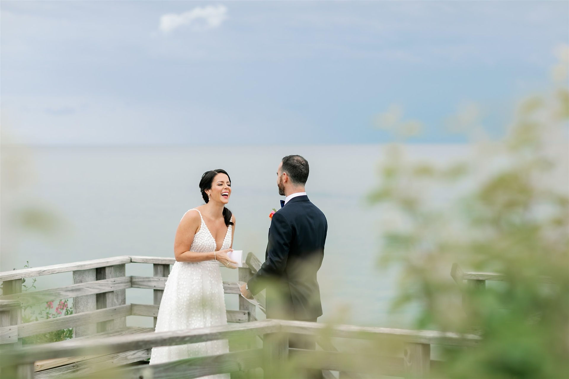 Bride and groom laughing reading personal vows at Cape Cod elopement