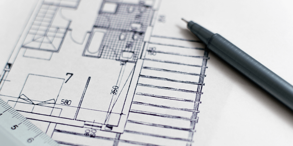An architectural blueprint with a pen and ruler.
