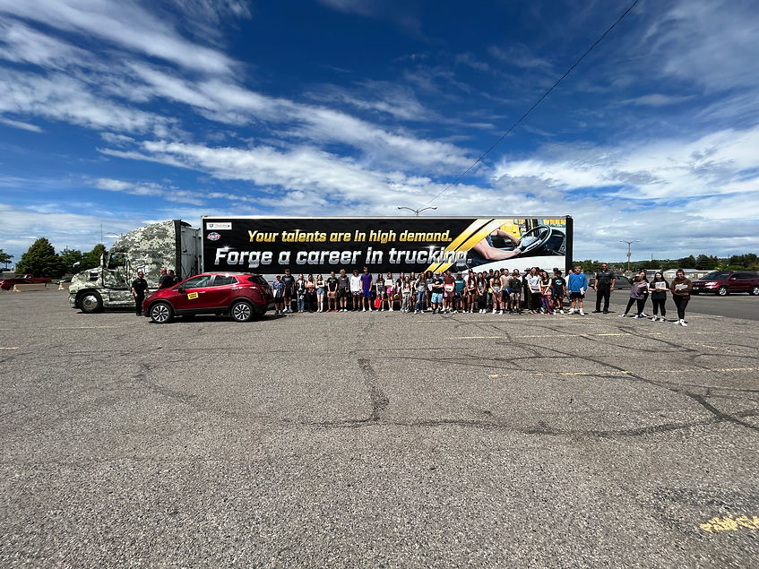 Semi truck in parking lot with crowd infront