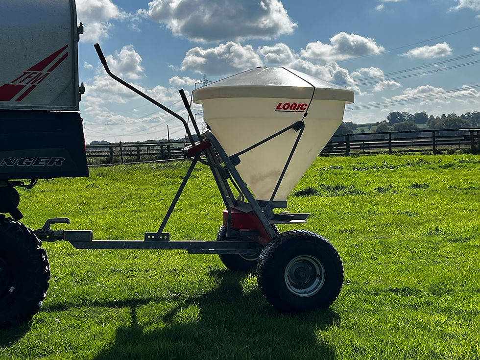 Close-up view of an ATV towing a small trailer loaded with equipment on a farm track