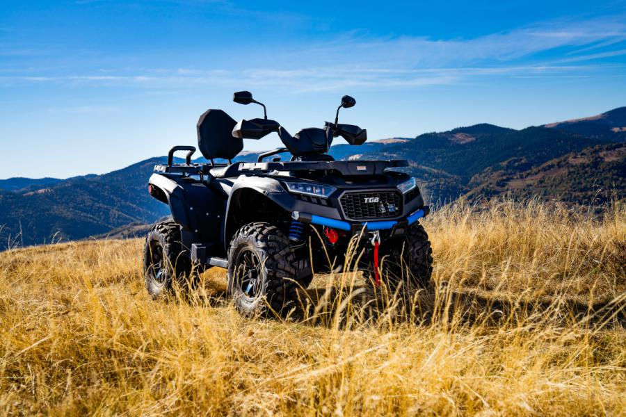 Close-up view of an ATV with a mower attachment cutting grass