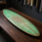 Green surfboard on a table at a Kava Bar Pompano Beach