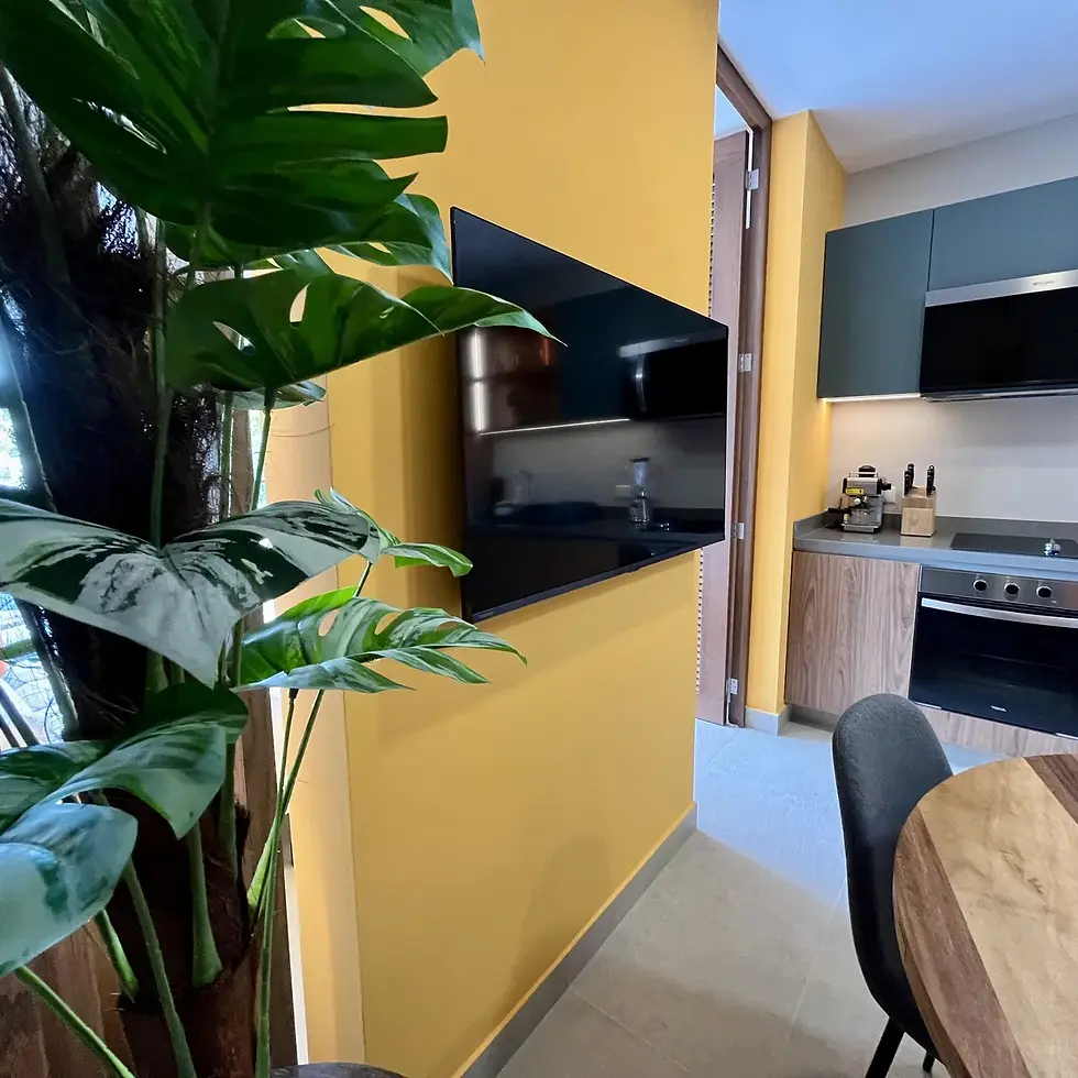 Staged kitchen and dining area with yellow wall
