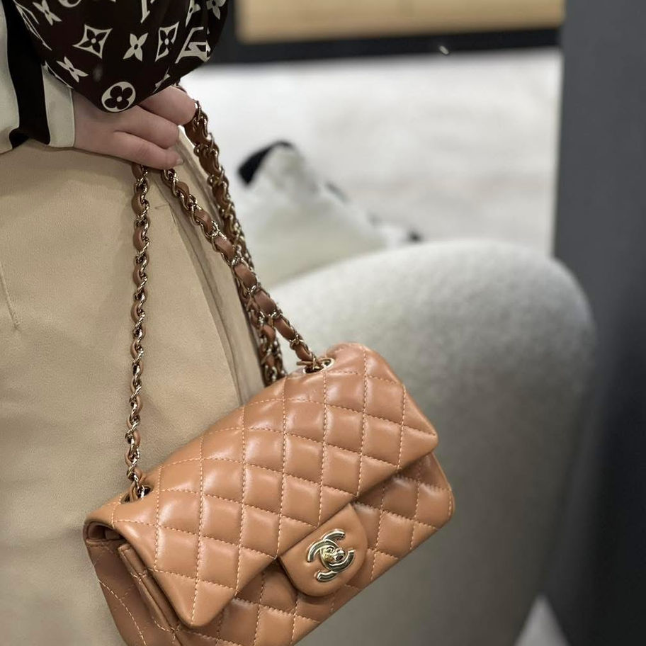 Woman holding Chanel rectangular handbag