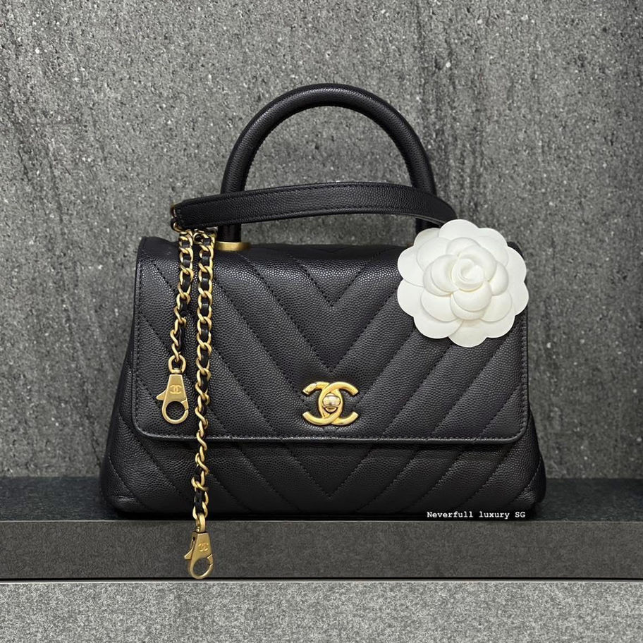 Black Chanel handbag with gold chain and camellia