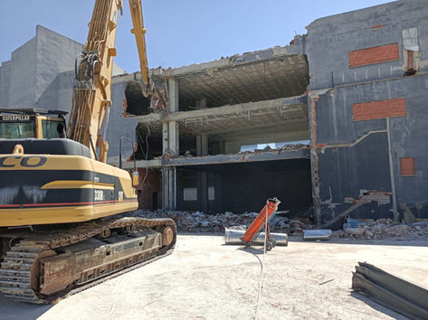 Excavador demoliendo un edificio con una grúa