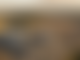 Aerial view of residential apartment buildings under construction alongside cleared development land with new road infrastructure in South-East Queensland at golden hour, illustrating the scale of Queensland's housing supply challenge.